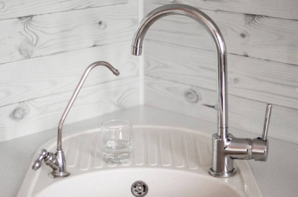 A regular tap and a filtered tap at a sink. 